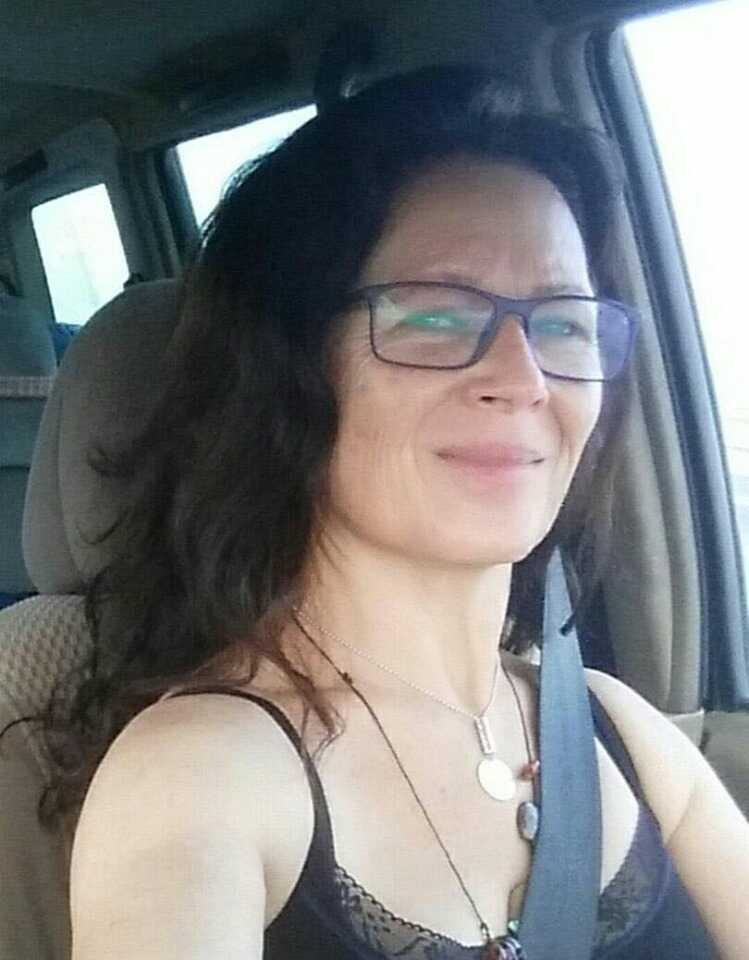 תמונת פורטרט של אישה ברכב, מחייכת